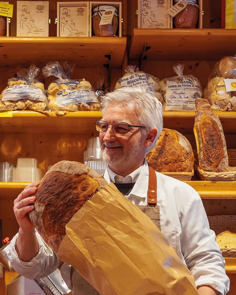 Il titolare con una forma di pane appena sfornato